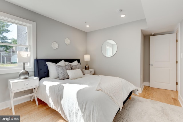 bedroom featuring light hardwood / wood-style flooring and multiple windows