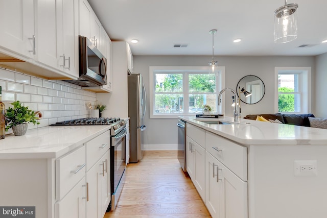 kitchen featuring stainless steel appliances, light hardwood / wood-style flooring, sink, and a wealth of natural light