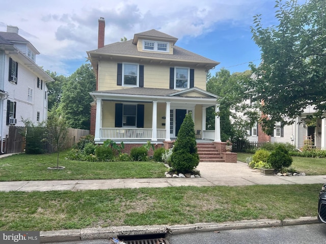 view of front of home with covered porch and a front lawn