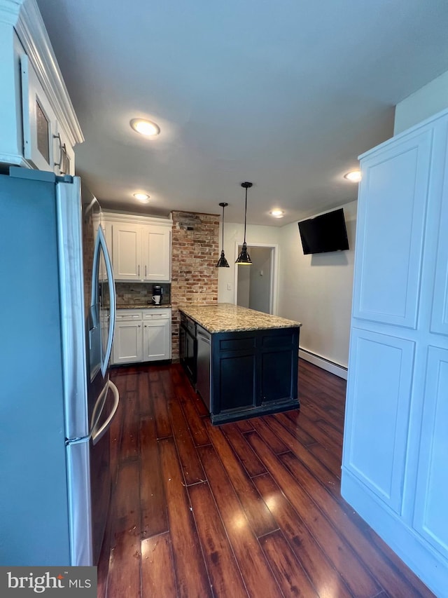 kitchen featuring pendant lighting, tasteful backsplash, a baseboard radiator, white cabinetry, and stainless steel refrigerator