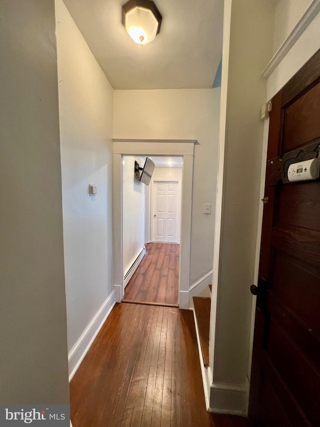 hallway with a baseboard radiator and dark hardwood / wood-style floors