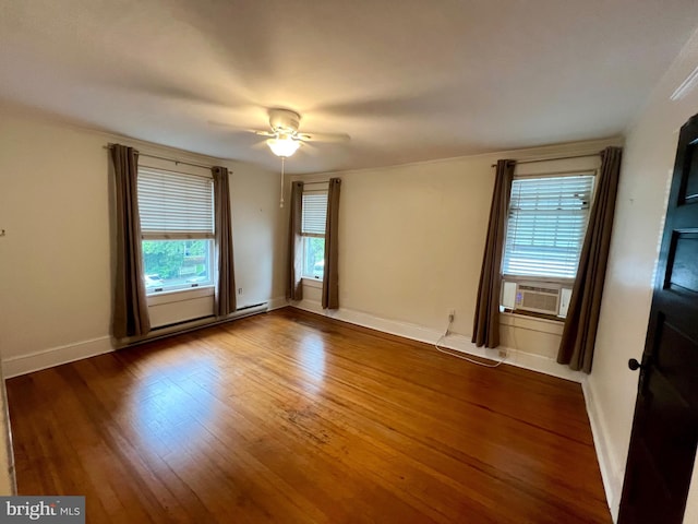 empty room with hardwood / wood-style floors, cooling unit, ceiling fan, and a baseboard heating unit