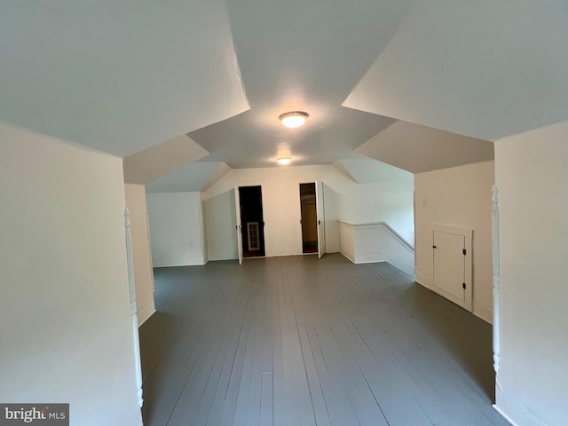 additional living space with wood-type flooring and vaulted ceiling