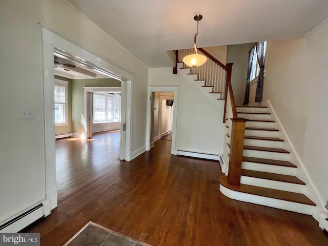 staircase featuring wood-type flooring and a baseboard heating unit