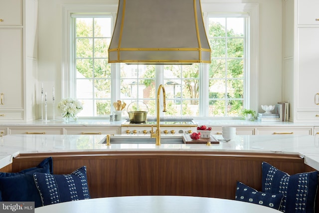 kitchen featuring white cabinets, a wealth of natural light, and custom exhaust hood