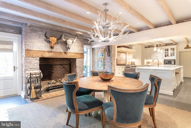 dining area featuring beam ceiling, dark hardwood / wood-style flooring, sink, and a chandelier