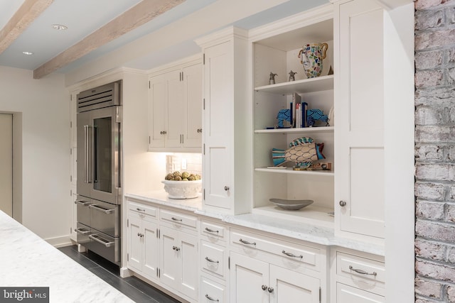 kitchen with dark hardwood / wood-style flooring, white cabinetry, stainless steel built in fridge, and light stone counters