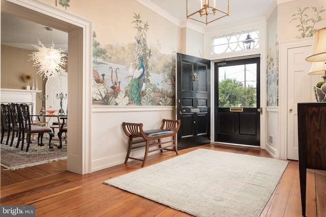 foyer entrance with a chandelier, hardwood / wood-style flooring, and crown molding