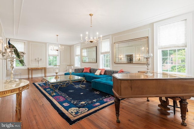 living room with a chandelier, hardwood / wood-style flooring, and crown molding