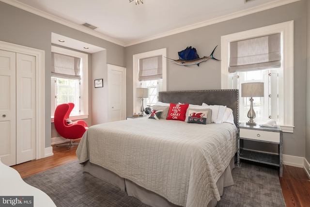 bedroom with crown molding, a closet, and dark wood-type flooring