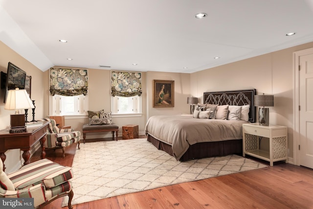 bedroom with light wood-type flooring and lofted ceiling