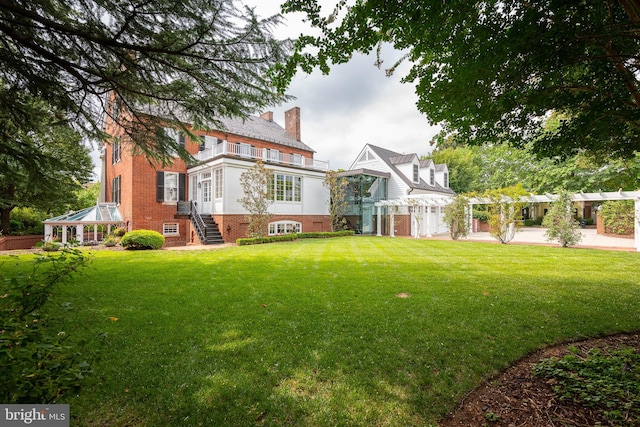 rear view of property featuring a lawn