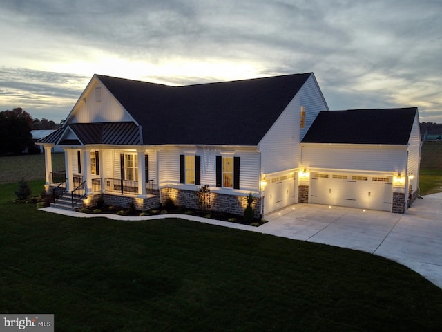 view of front of property featuring a yard, a porch, and a garage