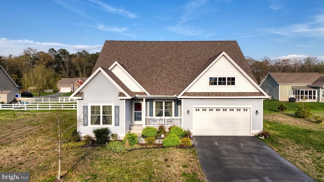 view of front of home featuring covered porch, a front yard, and a garage