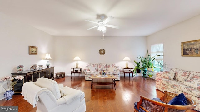 living room featuring ceiling fan and dark wood-type flooring