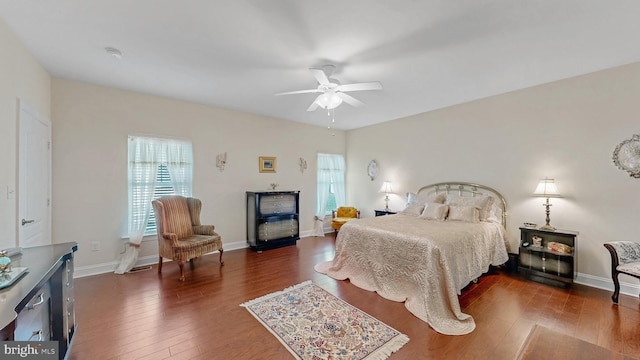 bedroom with multiple windows, dark hardwood / wood-style floors, and ceiling fan