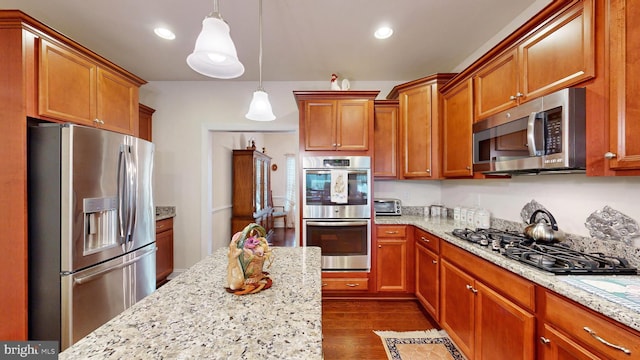 kitchen featuring dark hardwood / wood-style flooring, light stone countertops, stainless steel appliances, and hanging light fixtures