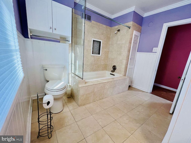 bathroom with tile patterned floors, tiled shower / bath combo, toilet, and ornamental molding