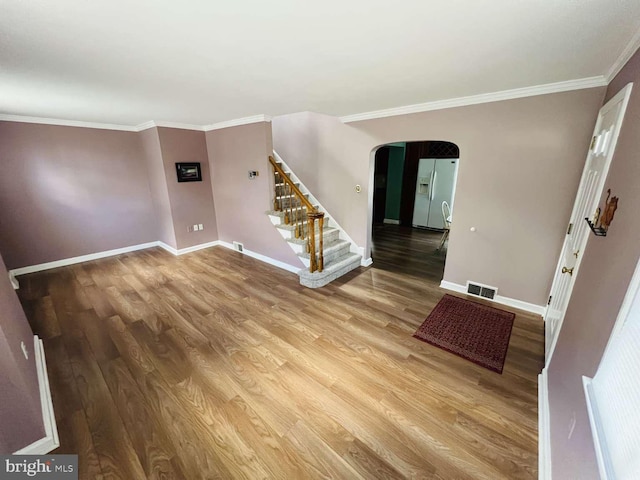 spare room with hardwood / wood-style flooring and crown molding