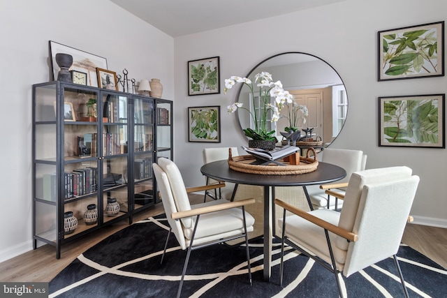 dining area with baseboards and wood finished floors