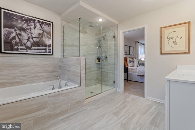 ensuite bathroom featuring vanity, a stall shower, connected bathroom, and a bath