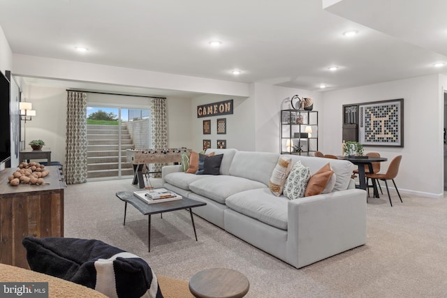 living area featuring baseboards, recessed lighting, and light colored carpet