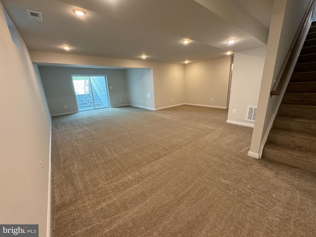 basement with carpet floors, visible vents, and stairway