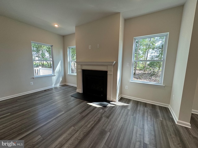 unfurnished living room featuring dark wood-style floors, a fireplace, and baseboards