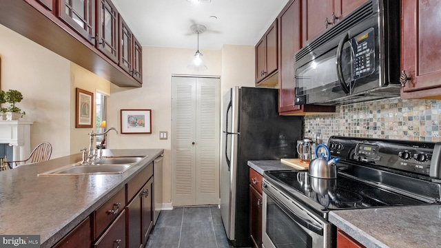 kitchen featuring backsplash, dark tile patterned flooring, sink, hanging light fixtures, and appliances with stainless steel finishes