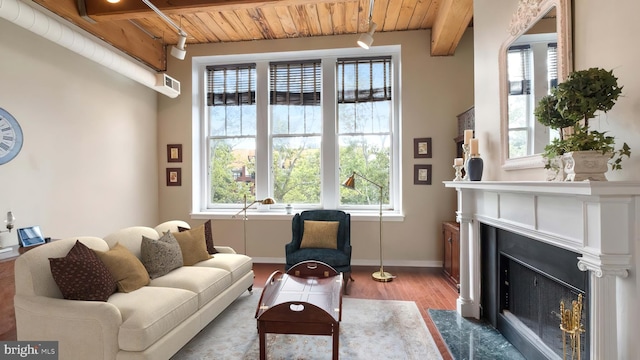 sitting room with hardwood / wood-style floors, beam ceiling, a healthy amount of sunlight, and wood ceiling