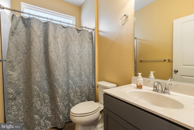 bathroom featuring toilet, vanity, and walk in shower