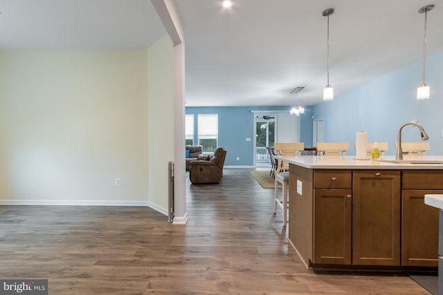 kitchen with sink, hanging light fixtures, and dark hardwood / wood-style floors