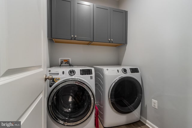 washroom featuring cabinets and washing machine and clothes dryer