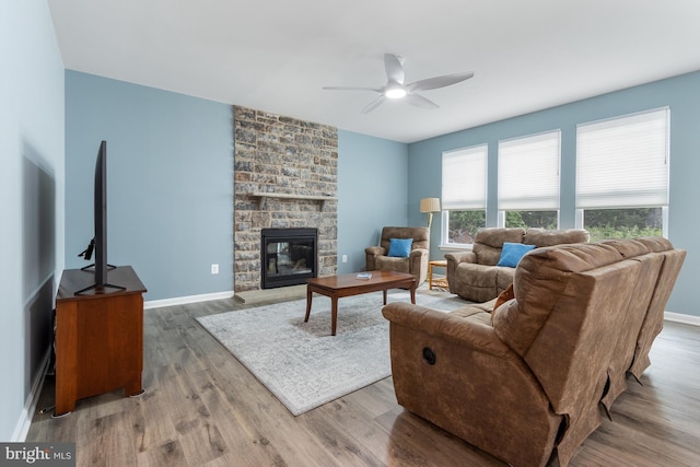 living room with ceiling fan, wood-type flooring, and a fireplace