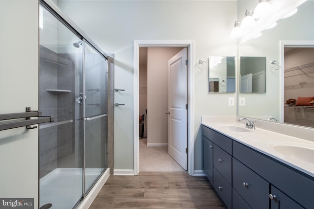 bathroom featuring vanity, hardwood / wood-style flooring, and a shower with door