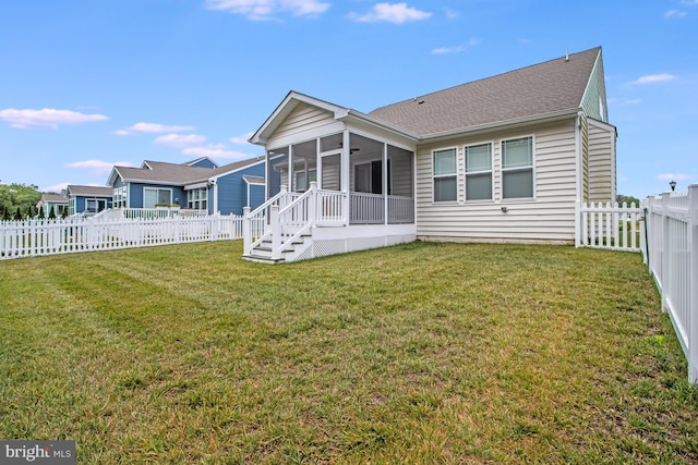 rear view of property featuring a yard and a sunroom