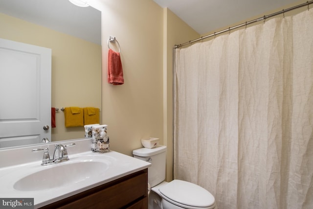 bathroom with toilet, vanity, and a shower with shower curtain