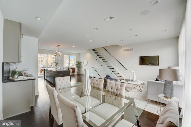 dining area featuring hardwood / wood-style floors, sink, and an inviting chandelier