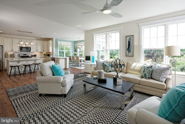 living room featuring ceiling fan with notable chandelier and dark hardwood / wood-style floors