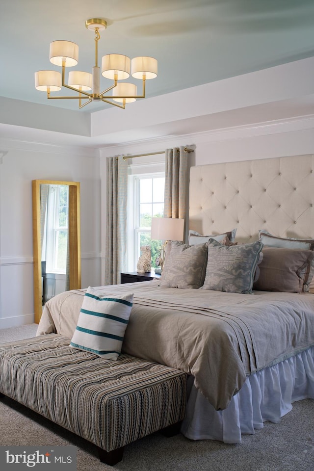 carpeted bedroom with an inviting chandelier