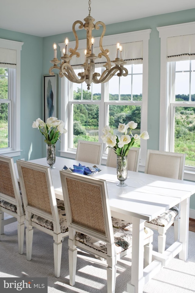 carpeted dining space with an inviting chandelier