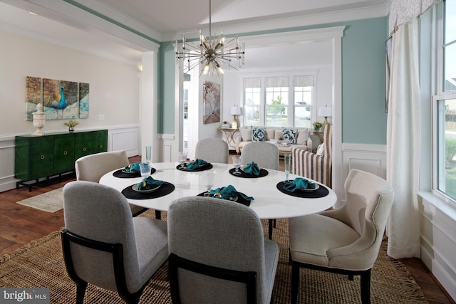 dining room featuring dark hardwood / wood-style floors, crown molding, and an inviting chandelier