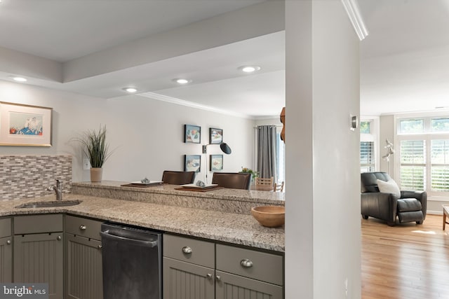 kitchen with light stone countertops, dishwasher, sink, and gray cabinets