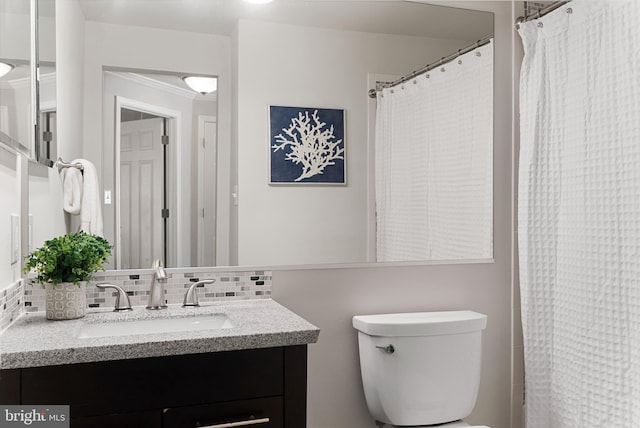 bathroom with tasteful backsplash, vanity, toilet, and crown molding