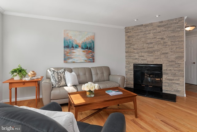 living room with light wood-type flooring, a fireplace, and ornamental molding