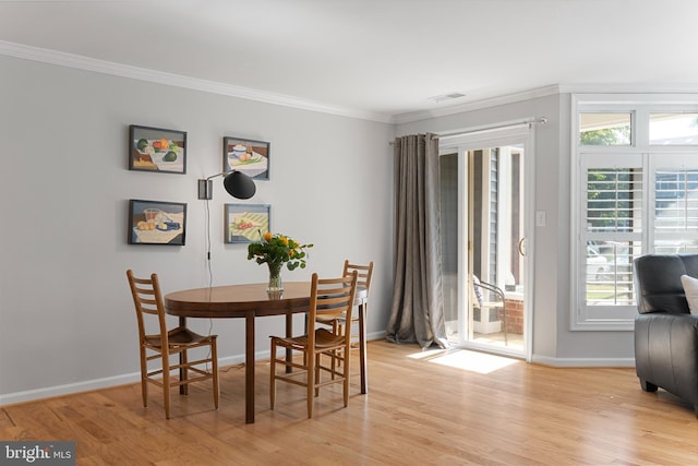 dining room featuring ornamental molding and light hardwood / wood-style flooring