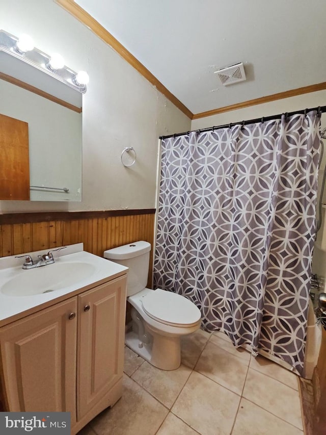 bathroom featuring wooden walls, vanity, ornamental molding, tile patterned floors, and toilet