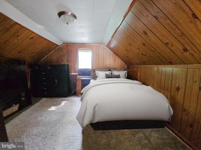 bedroom featuring wooden walls, carpet flooring, and vaulted ceiling