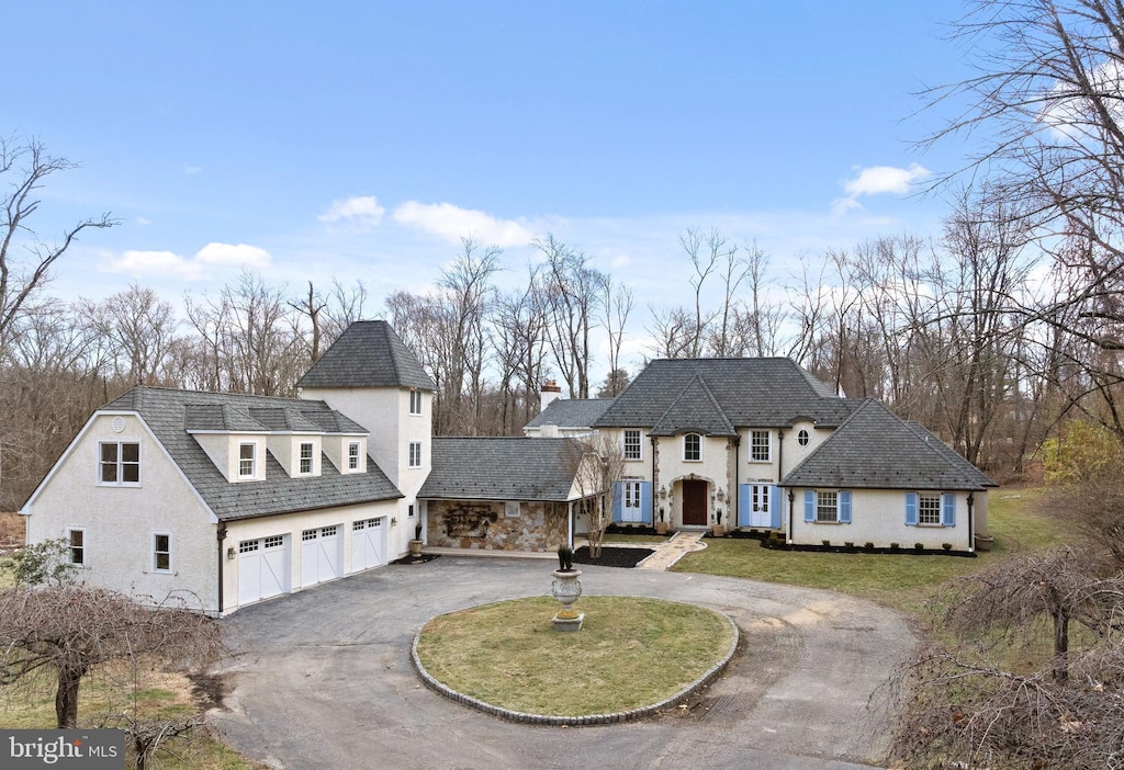 french country home with a garage and a front lawn