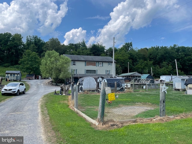 view of front of house with a storage unit and a front yard